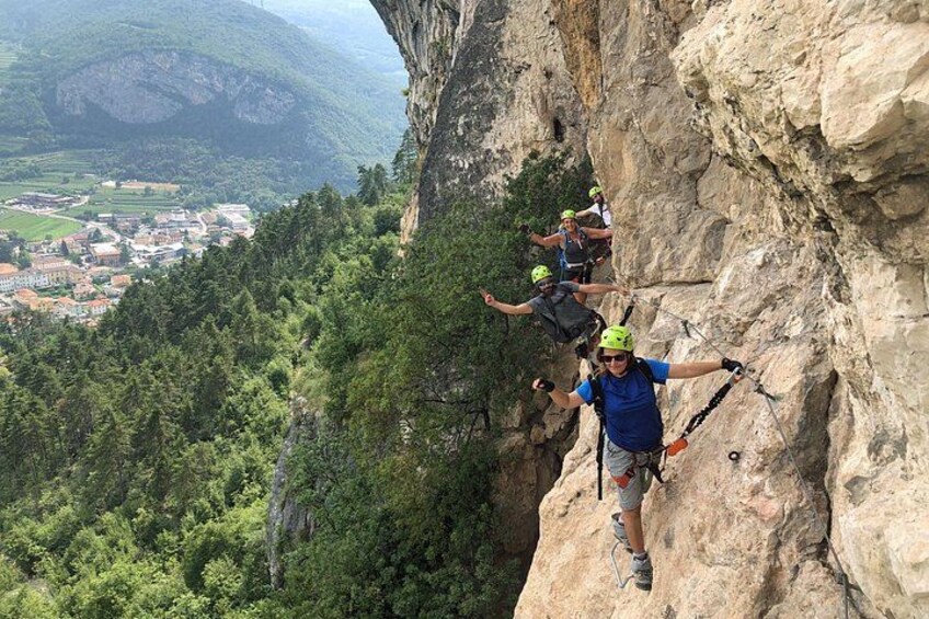 A person rappelling down a steep cliff with a town in the background. 5