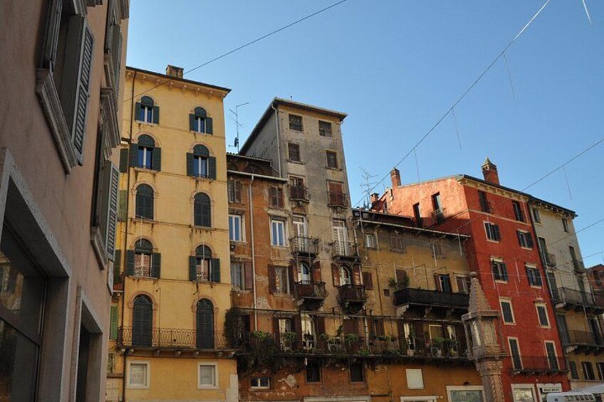 A row of multi-story buildings with balconies and windows, under a clear sky. 3