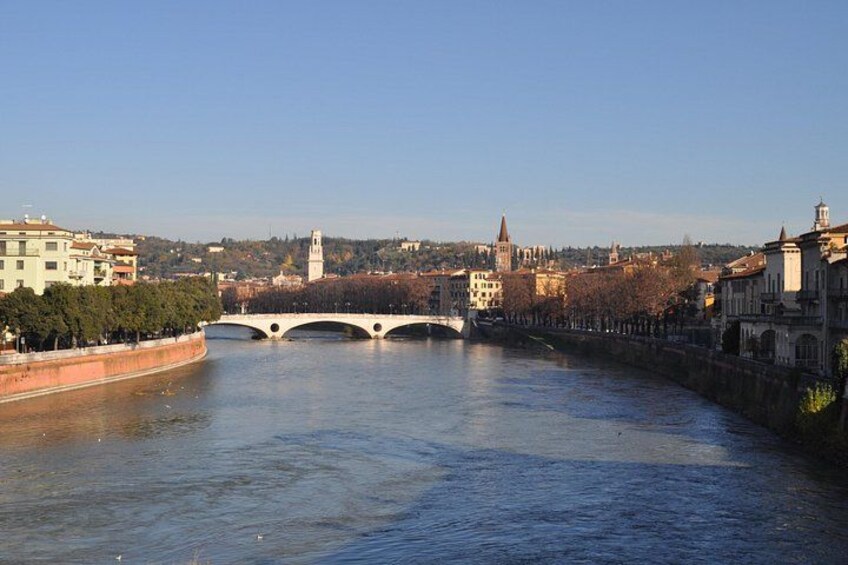 A river with a bridge, buildings, and a tower in the background. 5