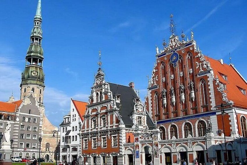 A historic European town square with ornate buildings, a church spire, and a clock tower. 3