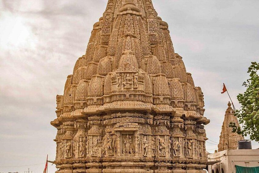 A detailed stone temple with intricate carvings and a flag on top. 4