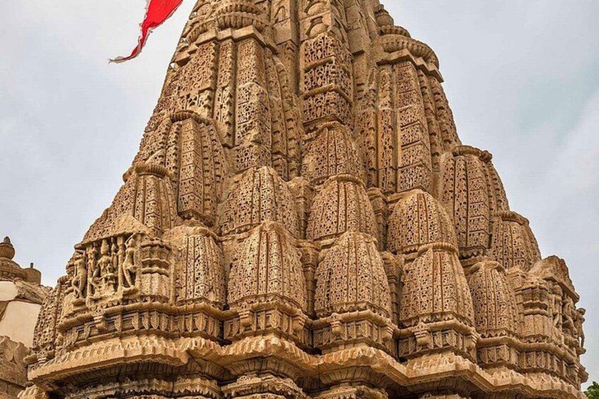A detailed stone temple with intricate carvings and a flag. 3