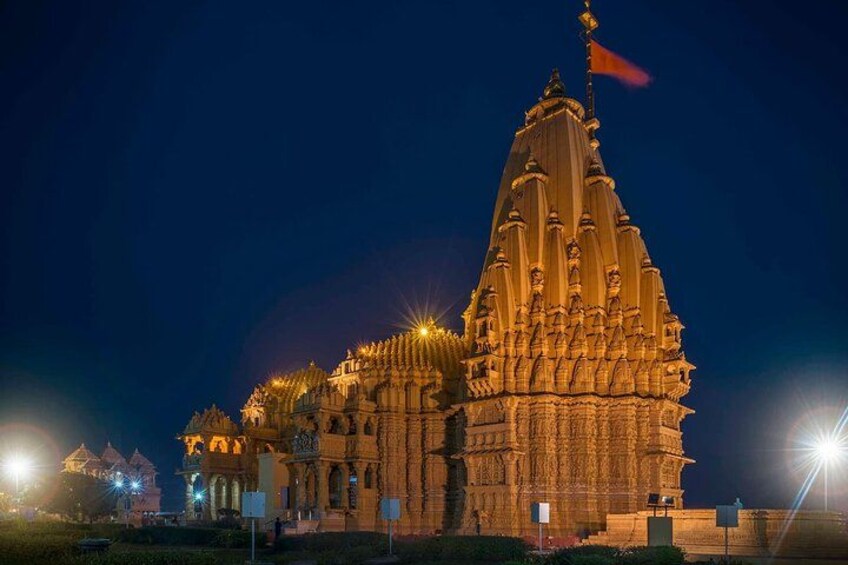 A large, intricately designed temple at night, illuminated by artificial lights. 2