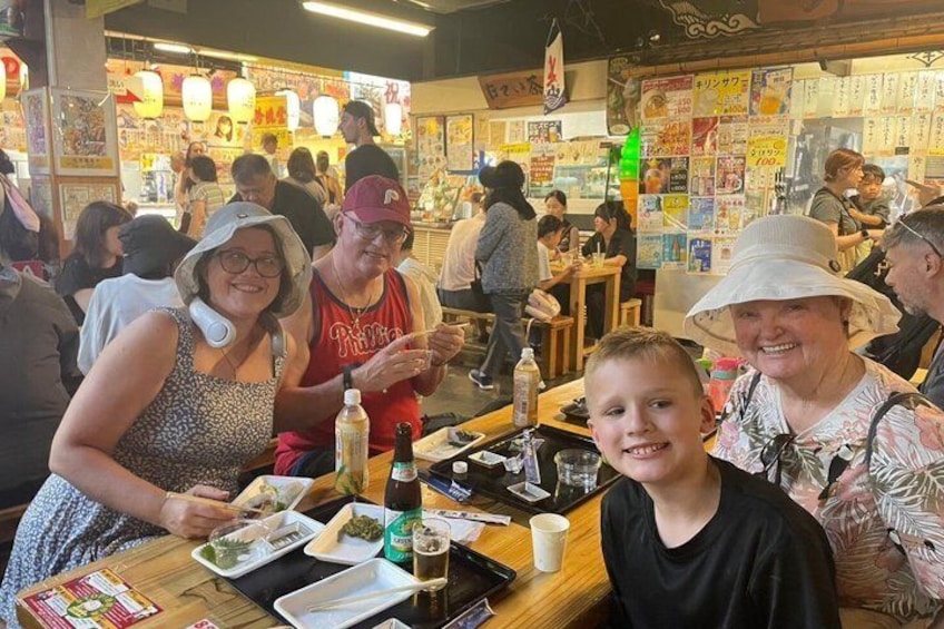 Un restaurante concurrido, con gente cenando y un panel de menú al fondo. 1