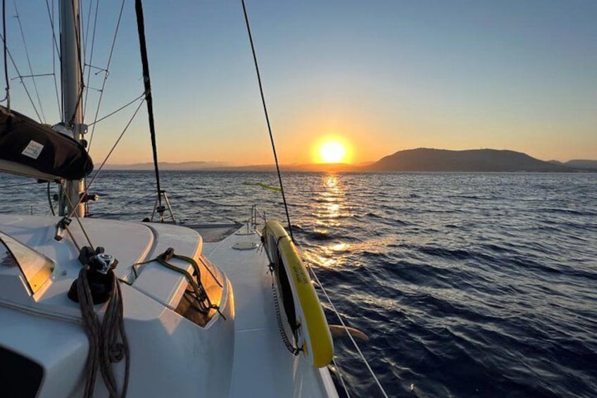 Un voilier au coucher du soleil, avec le soleil se reflétant sur l’eau. 5