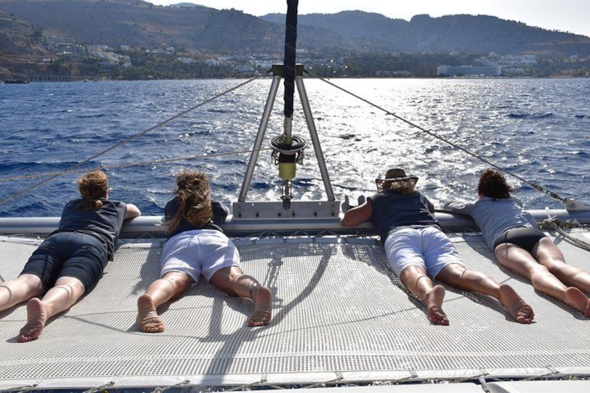 Quatre personnes sont allongées sur le pont d’un bateau, face à la mer. 3