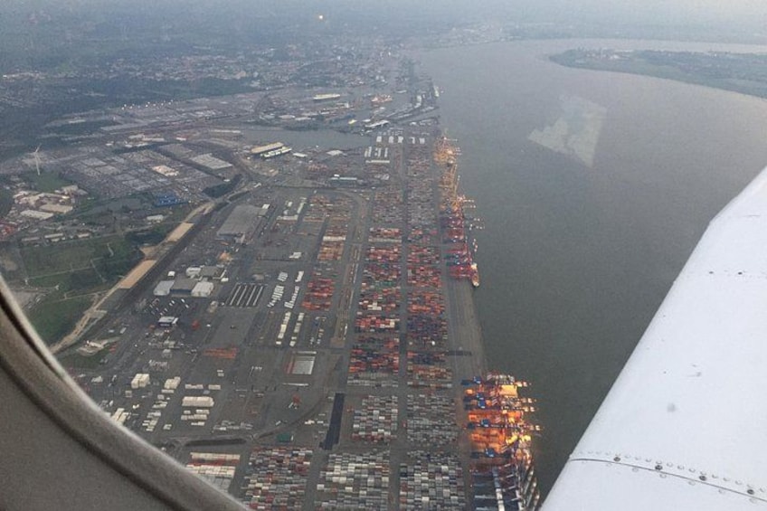 En vy över en hamn från ovan, med lastcontainers och en stor vattenyta. 3