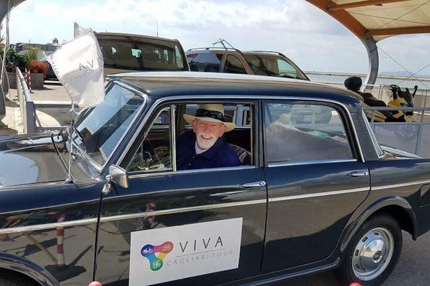 Ein Oldtimer mit einem 'VIVA'-Logo an der Seite, der unter einer Markise parkt. 2