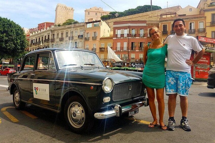 Un coche antiguo estacionado en una calle con edificios al fondo. 2