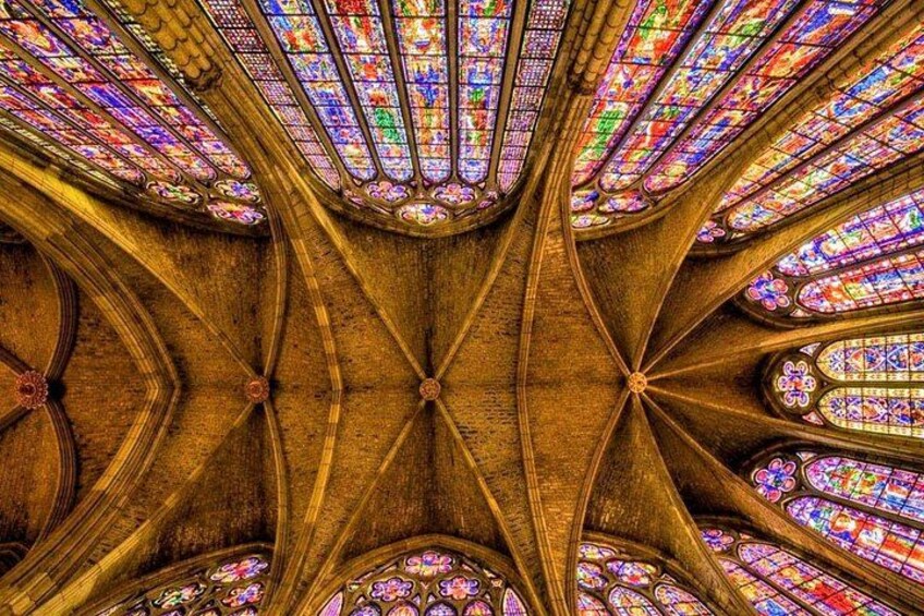 A cathedral ceiling with intricate stained glass windows and wooden beams. 4