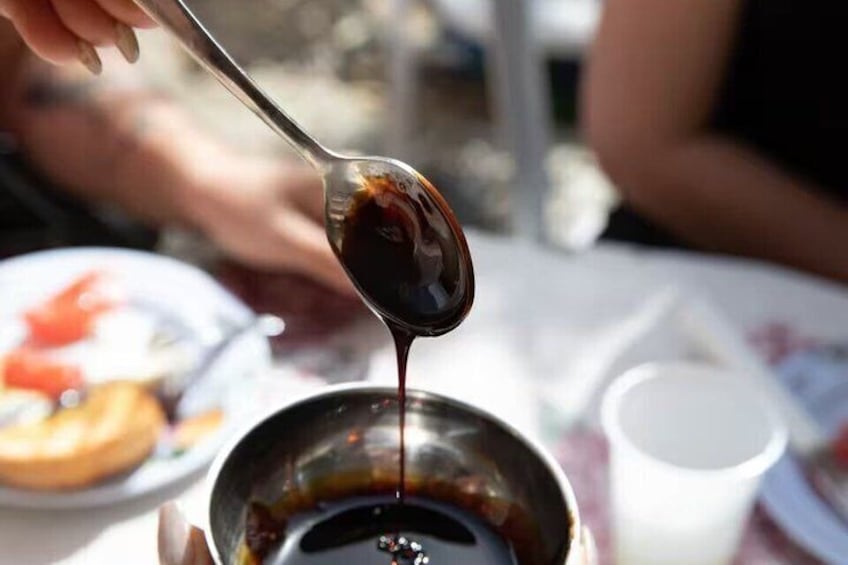 A spoonful of dark liquid being poured into a bowl. 3