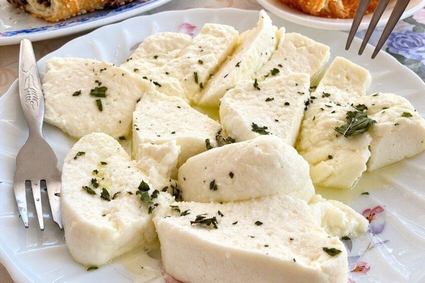 A plate of white cheese garnished with herbs. 4