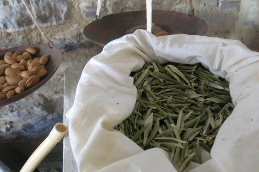 A sack filled with green beans and a wooden bowl with almonds. 5