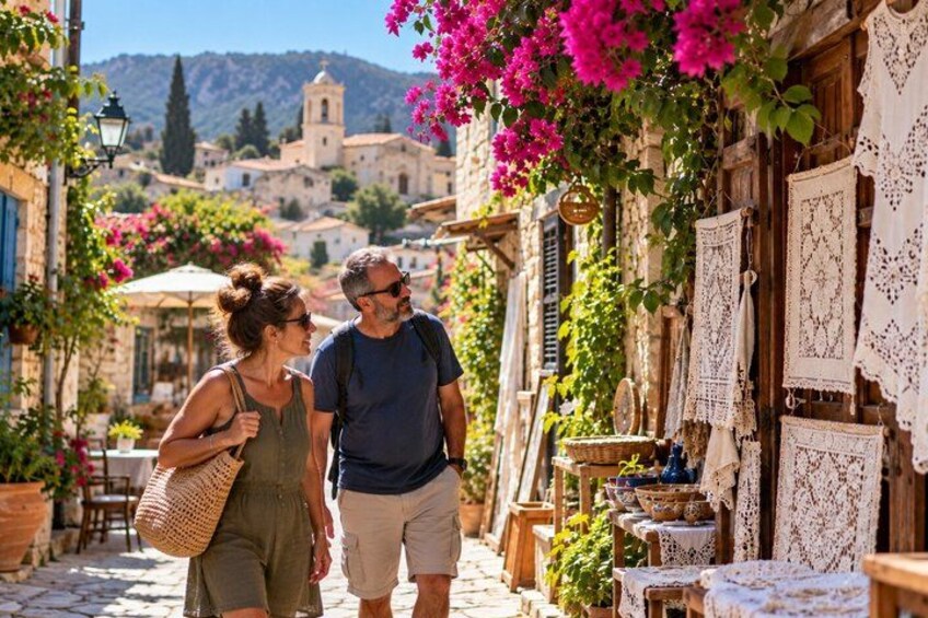A couple walking down a cobblestone street with buildings on either side, some with lace decorations. 1