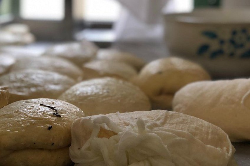 A collection of round, white pastries on a surface. 4