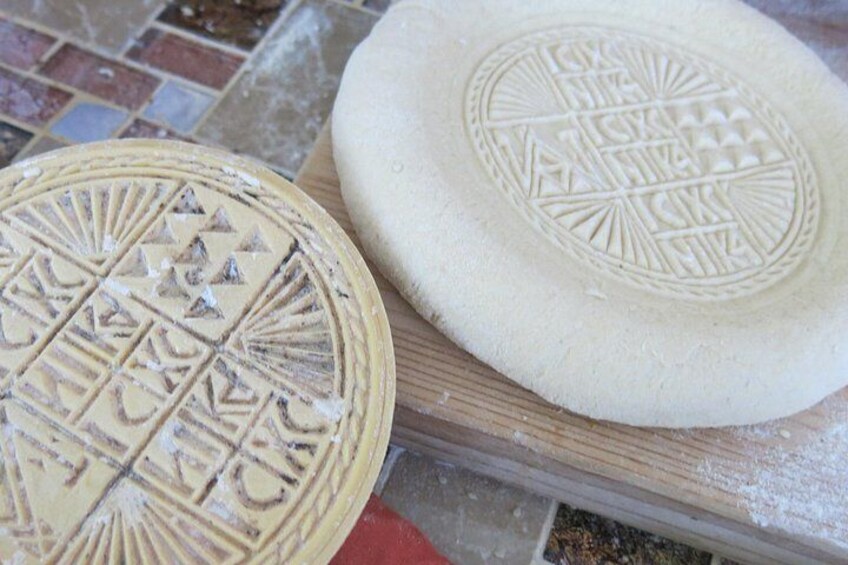 Two round, flat objects with intricate patterns on a wooden surface. 3