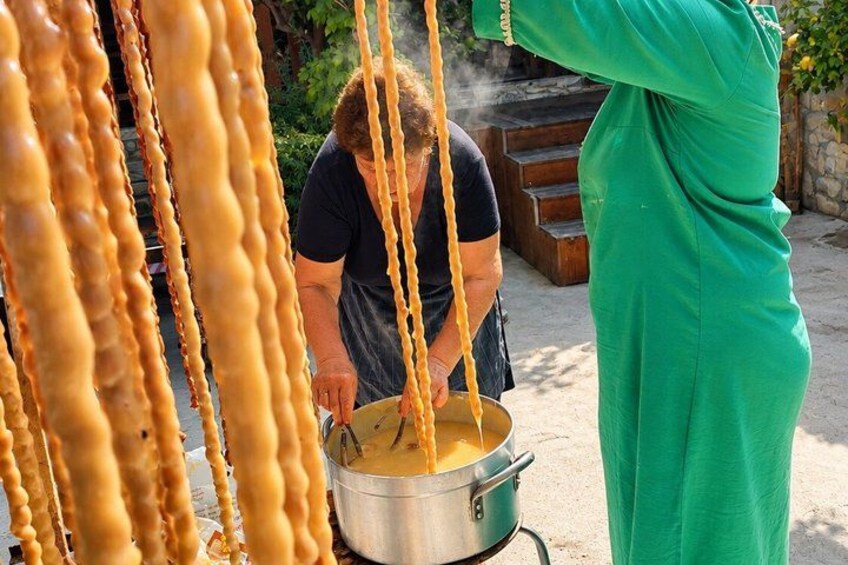 A person cooking with a pot on a stove, surrounded by hanging food items. 5