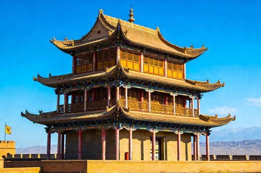 A multi-tiered traditional Chinese building with ornate roof details and a clear blue sky in the background. 5