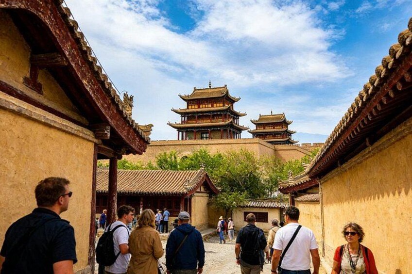 A traditional Chinese courtyard with tourists walking, surrounded by ancient buildings with multiple tiers. 3