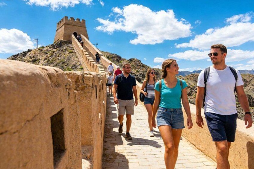 A group of people walking on a stone pathway with a castle-like structure in the background. 1