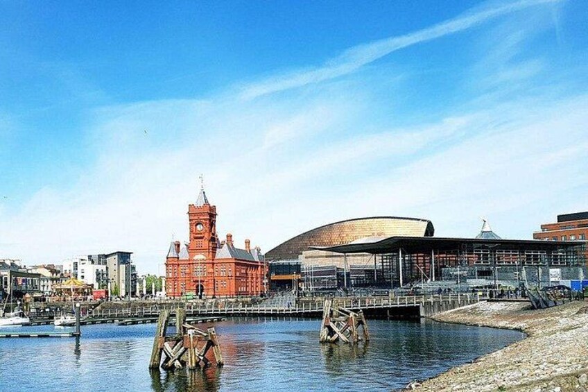 A waterfront with a red building and a modern structure. 1