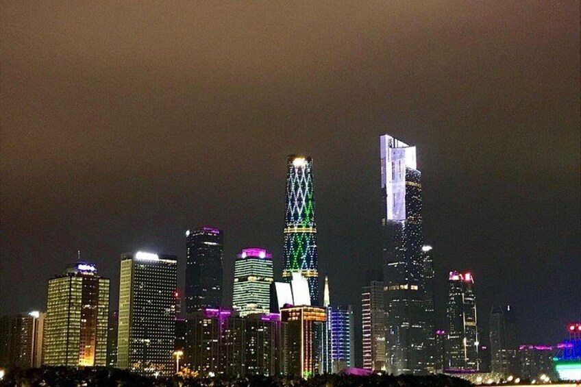 A city skyline at night with illuminated buildings. 5