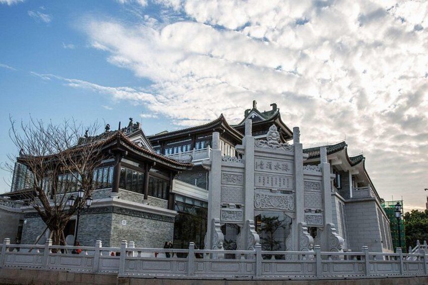 A traditional Chinese building with ornate architecture, a stone pathway, and a white fence. 3
