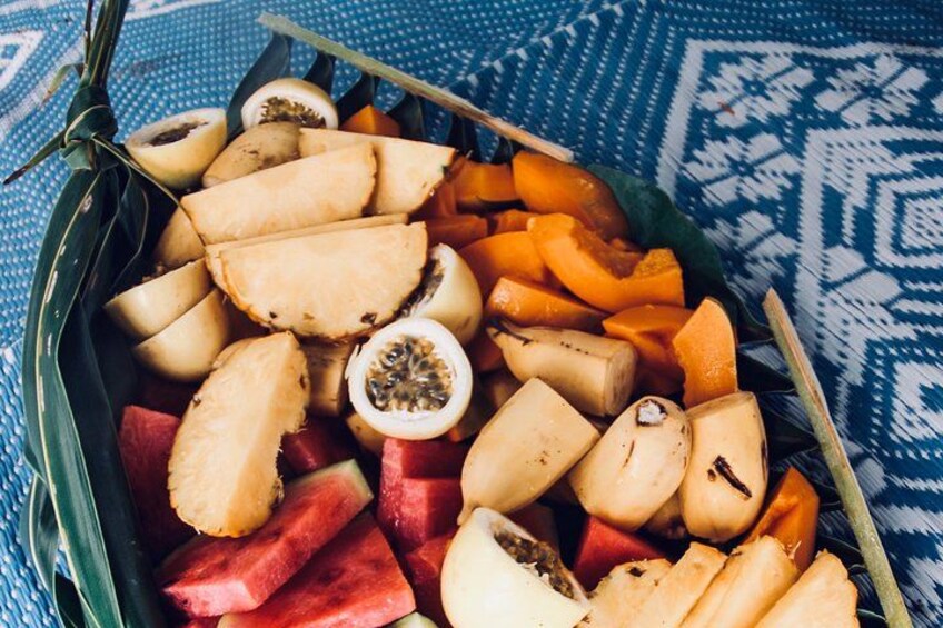 A variety of fruits including watermelon, passion fruit, and papaya arranged in a woven basket. 2