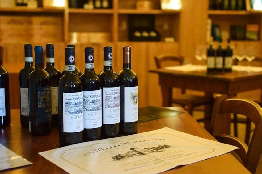 Un tavolo in legno con diverse bottiglie di vino e un menu. 1
