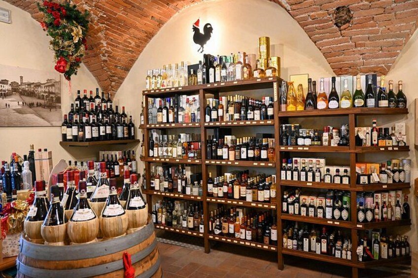 Una cantina vinicola con scaffali in legno e botti, con una decorazione a forma di gallo sul soffitto. 3