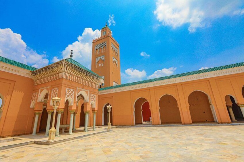 A courtyard with arches, a tower, and a tiled floor. 2