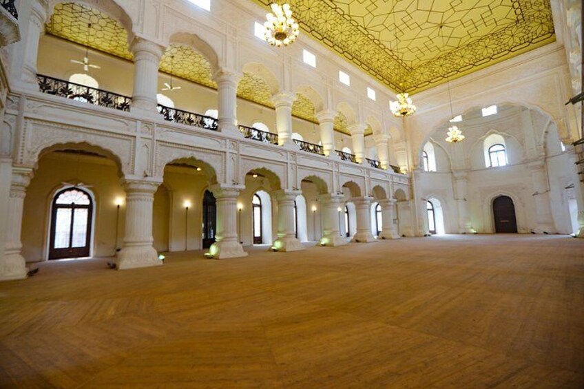 A grand hall with high ceilings, arched doorways, and ornate chandeliers. 4