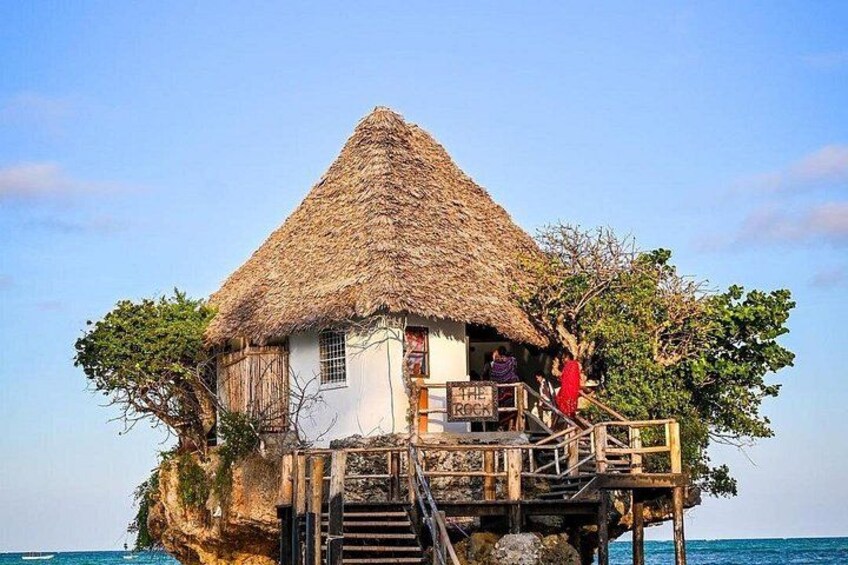 Une maison sur pilotis, avec un toit de chaume, qui surplombe l’eau. 5