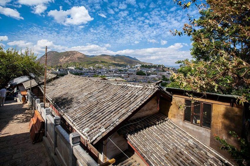 Edificios de madera tradicionales con tejados de tejas, un paisaje montañoso al fondo y un cielo despejado. 3