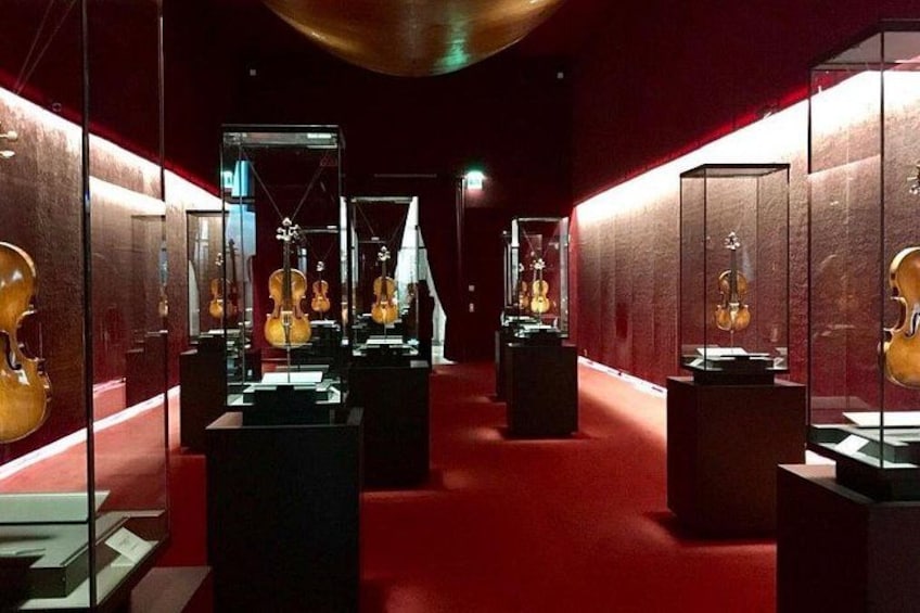 Un pasillo de museo con vitrinas de vidrio que exhiben instrumentos musicales. 5
