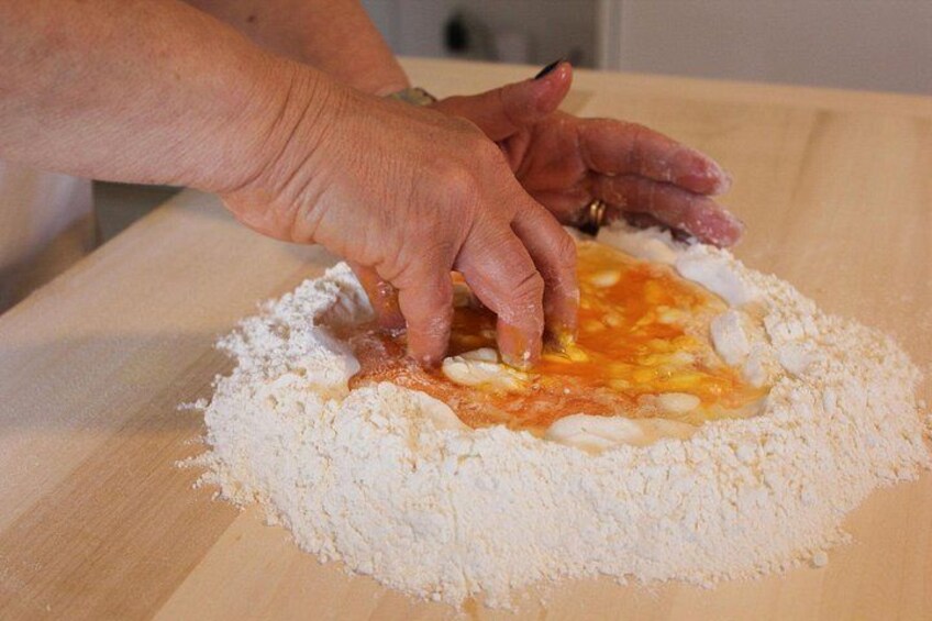 A person mixing ingredients in a bowl. 1