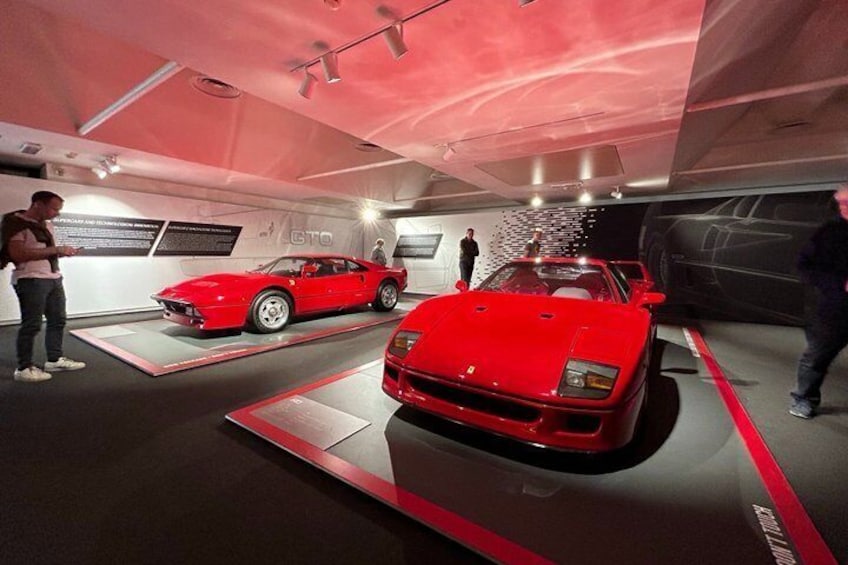 Un coche deportivo rojo exhibido en un museo con una decoración interior moderna. 2