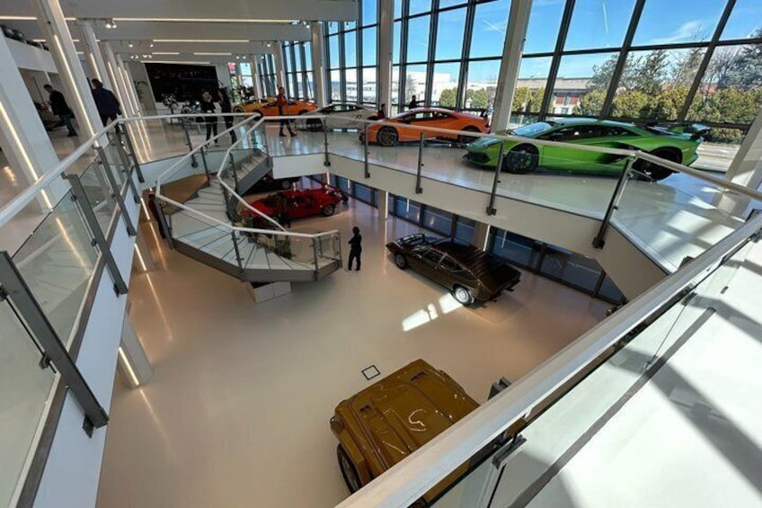 Een meerlaags autodealershowroom met diverse sportauto's. 3