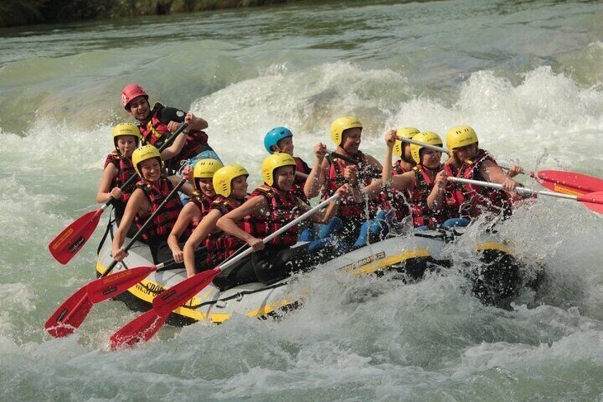 A group of people in a white and yellow raft navigating through whitewater rapids. 1