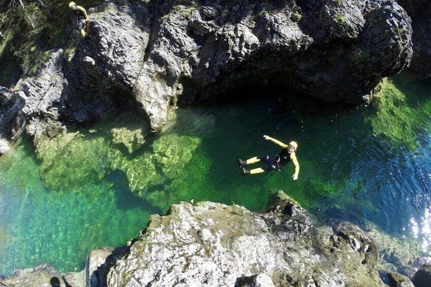 A person snorkeling in clear water surrounded by rocky formations. 5