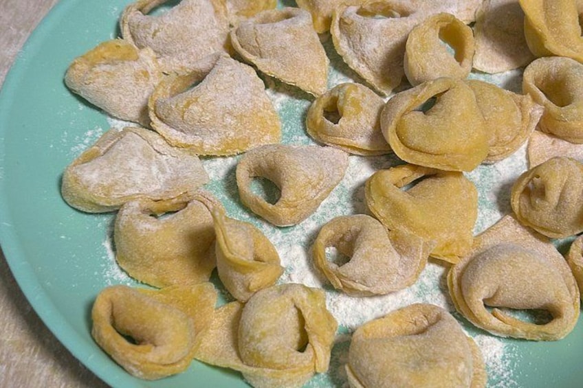 Un plato de ravioles crudos espolvoreados con harina. 5