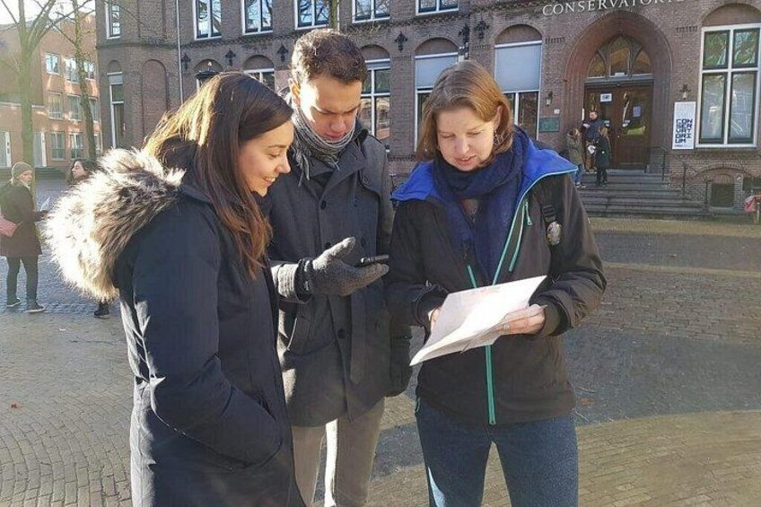 Tre persone in piedi all'aperto vicino a un edificio con un cartello che recita 'CONSERVATION'. 4
