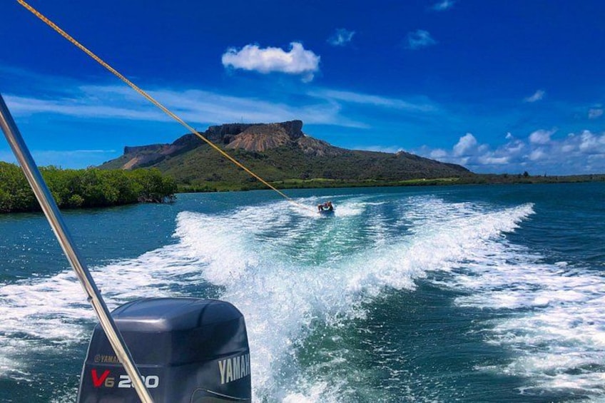 A wakeboarder on a body of water with a mountainous landscape in the background. 2
