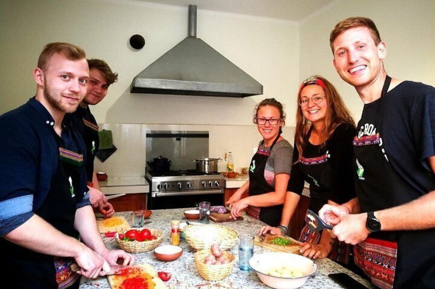 A group of people in a kitchen preparing food. 5