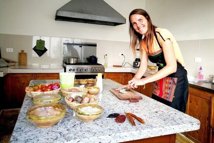 A kitchen with a woman chopping vegetables on a granite countertop. 4