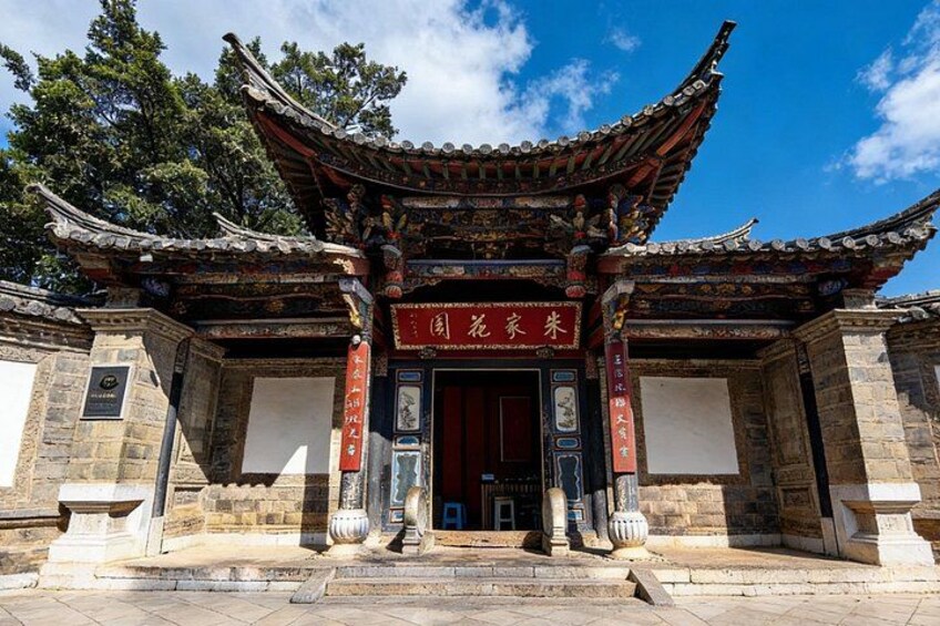 A traditional Chinese gate with intricate roof design and stone pillars. 3