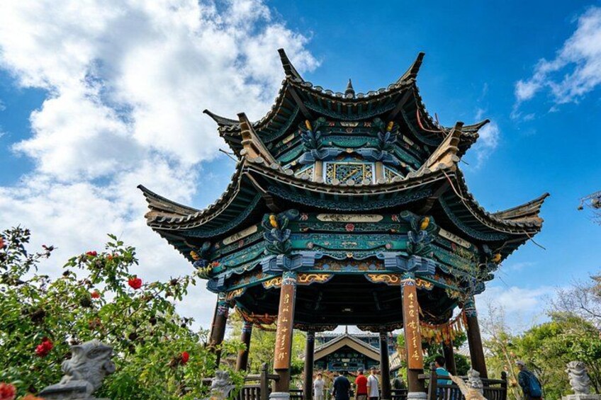 A traditional Chinese pavilion with ornate architecture, surrounded by lush greenery and flowering plants. 5