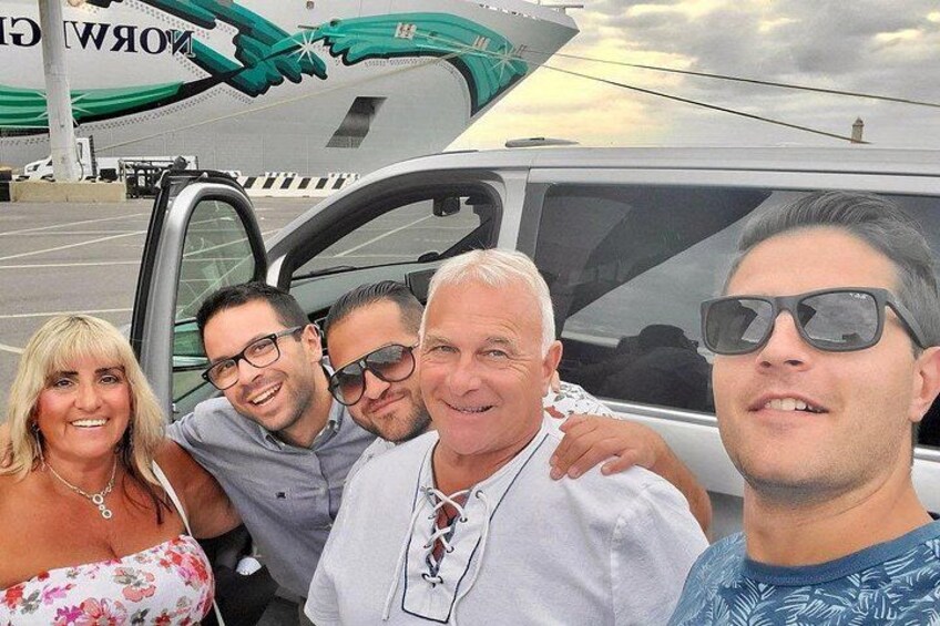 Un grupo de personas posando frente a un vehículo con un logotipo en la carrocería. 3