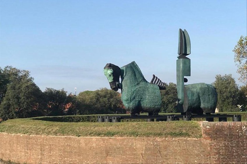 A large bronze sculpture of a horse and a knife in a park. 2