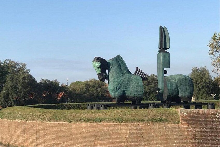 A large sculpture of a horse and a knife in a park. 2